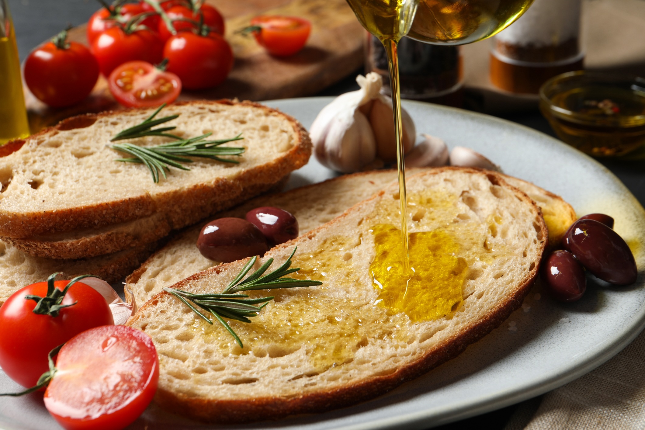 Pouring oil onto slice of bread on plate