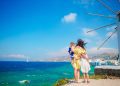 Happy family in front of windmills at popular tourist area on Mykonos island, Greece