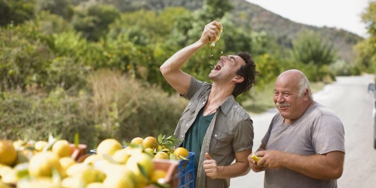 Men squashing oranges