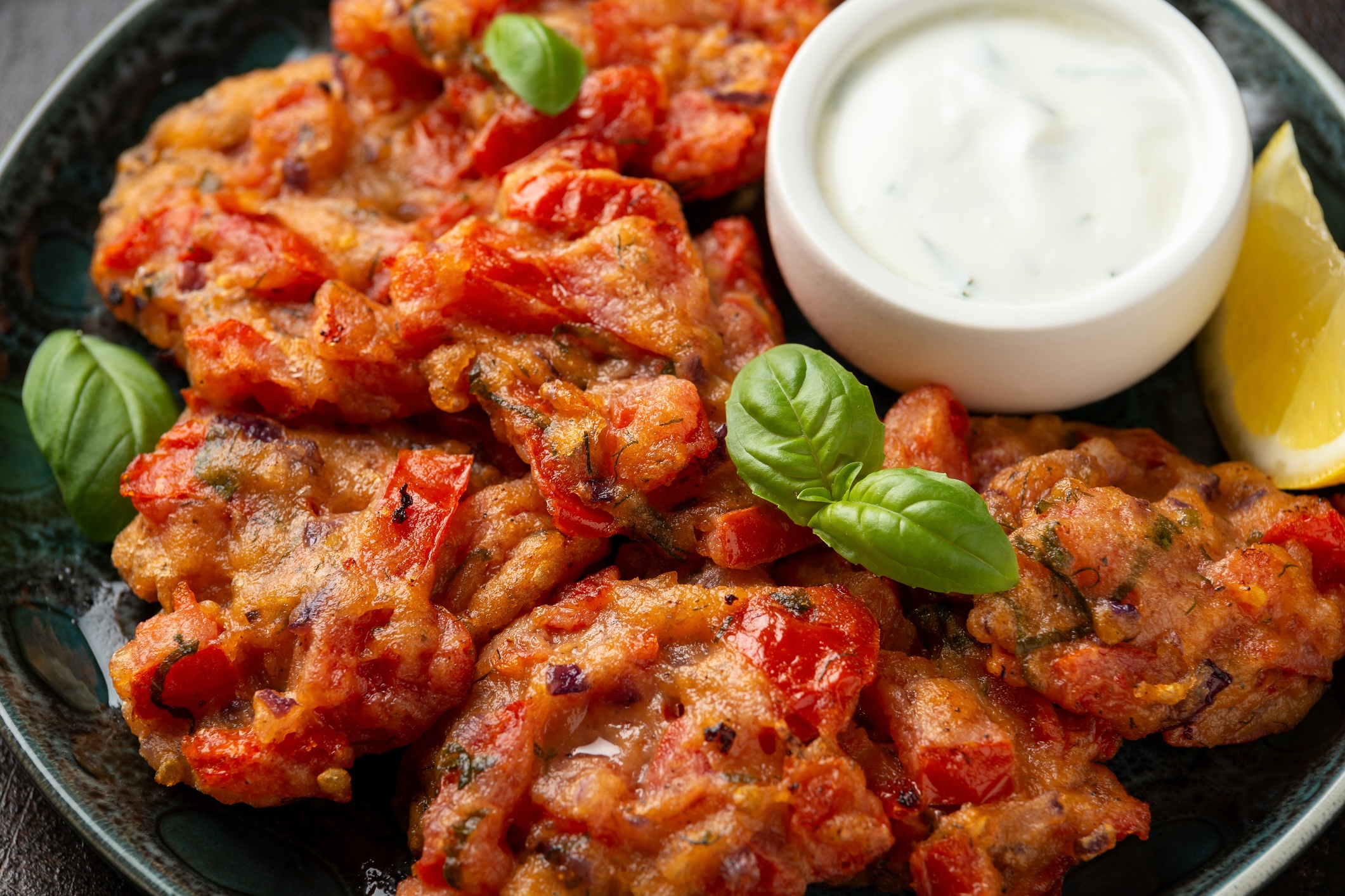 Greek tomato fritters, tomatokeftedes served with yogurt on plate.