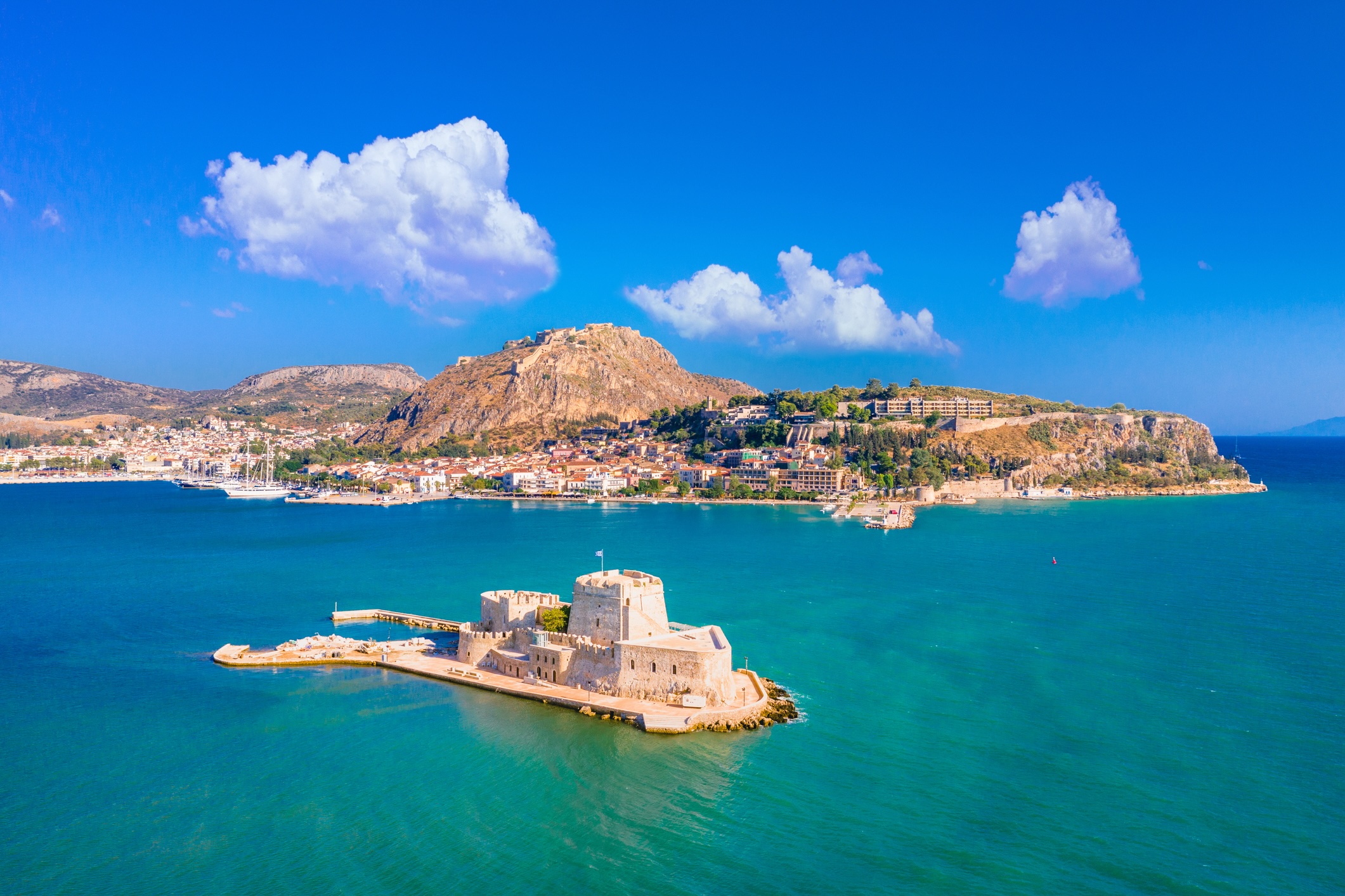 The old town of Nafplion in Greece with tiled roofs, small port, bourtzi castle, Palamidi fortress