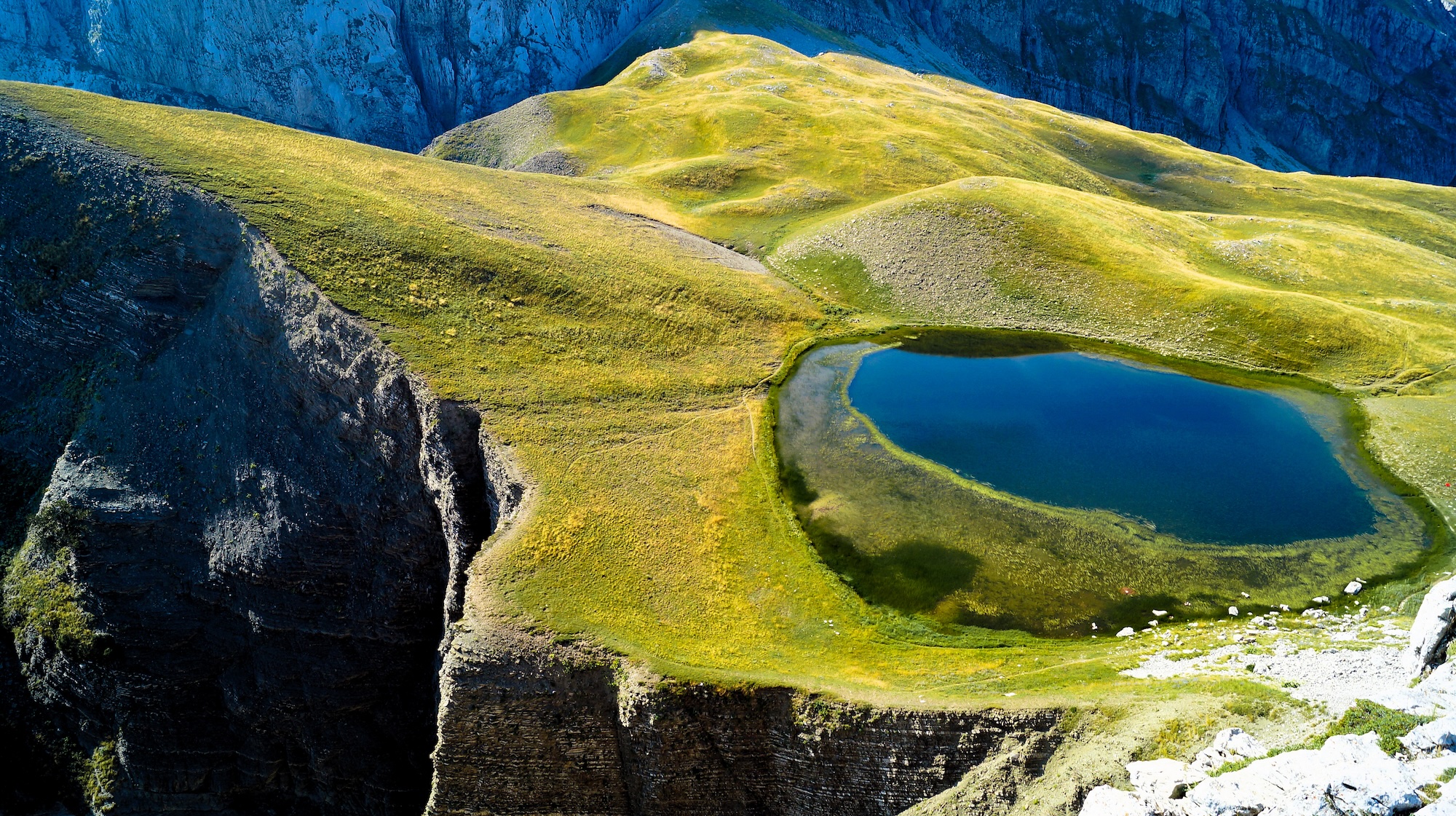 The pristine alpine lake of Drakolimni high in the mountains at the Zagori area, Epirus.