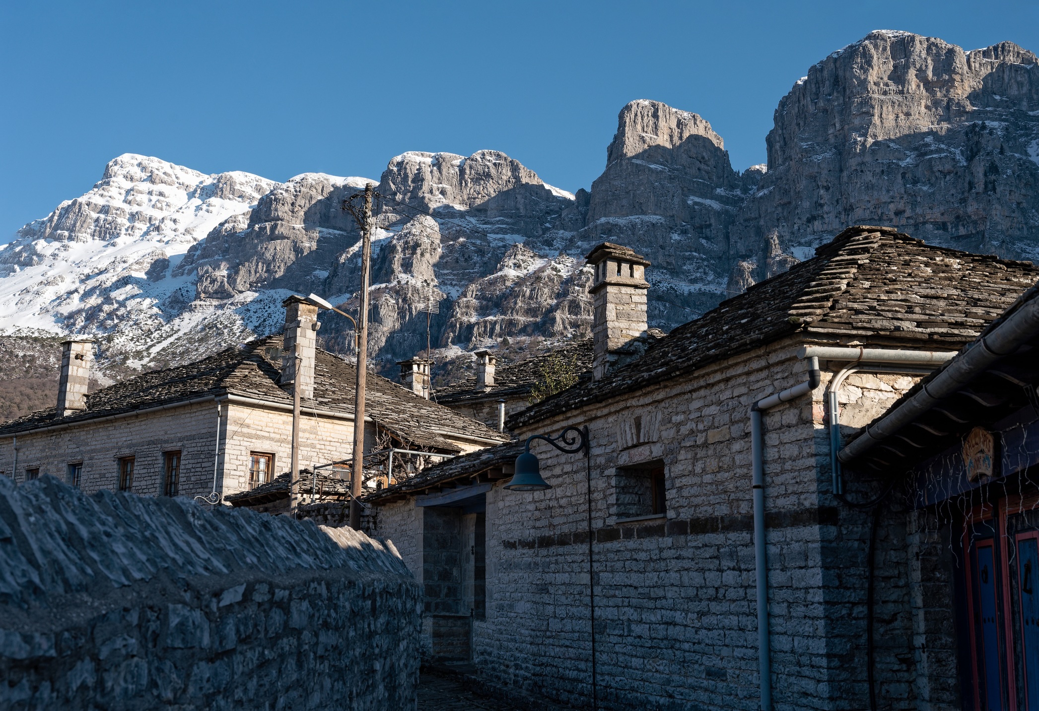 Stone houses of traditional architecture and cobble-stone narrow street at the village of Papigo in Epirus, Greece in winter