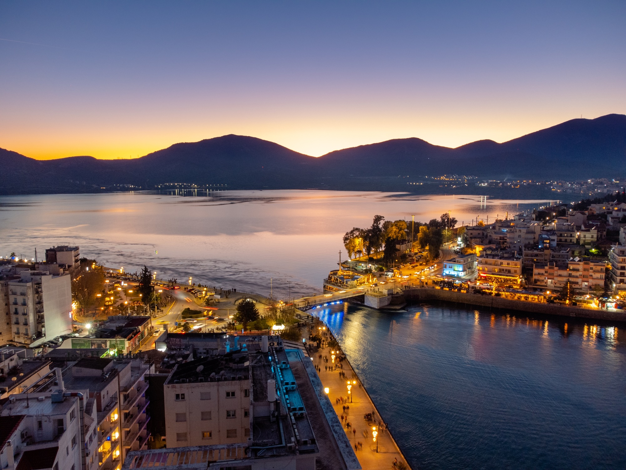 Aerial panoramic photo of the old bridge and the city center of Halkida, Chalkida in Evia, Greece at night