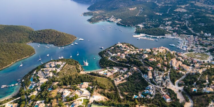 View from above, stunning aerial view of a bay with boats and luxury yachts sailing on a turquoise, clear water. Syvota, Greece.