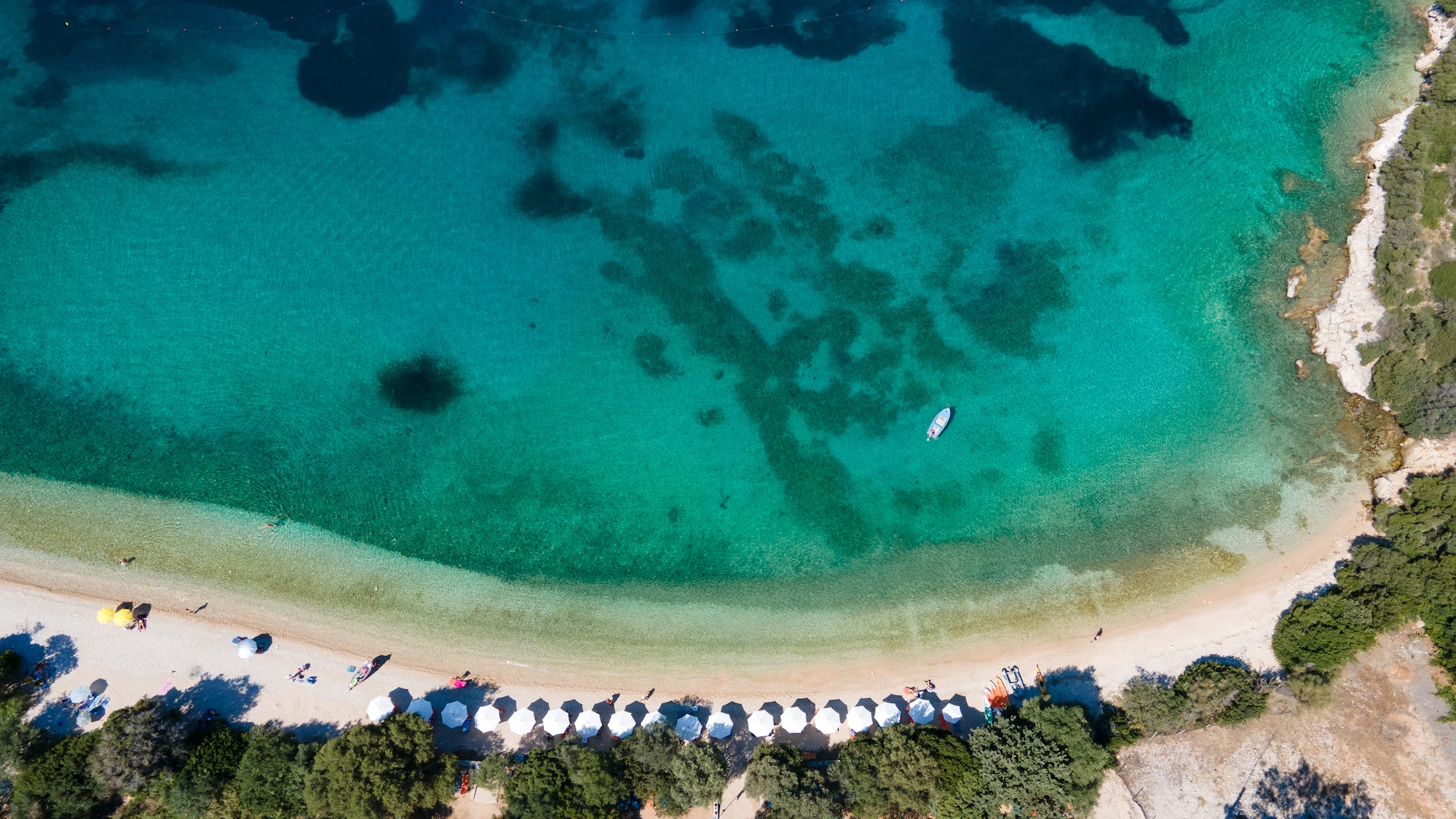 Tropical beach with sea and palm taken from drone. Greece famous beach in Syvota - aerial photo. Summer palm tree and Tropical beach with blue sky background