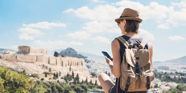 Woman using smart phone on vacations in Athens